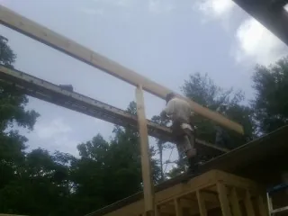 Carpenter setting a ridge beam over a new addition frame — Ice Dam Removal by Roofing Brothers in Painter