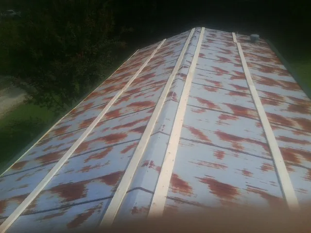 Rusted metal roof panels with new wood purlins before replacement — Storm Damage Roof Repair in Painter by Roofing Brothers